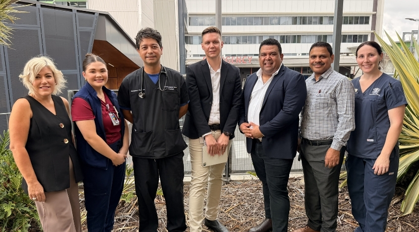 Group of Central Queensland Health staff, including Chief Executive Lisa Blackler and Board Chair Matthew Cooke, standing outdoors in front of the Rockhampton Hospital Emergency Department.