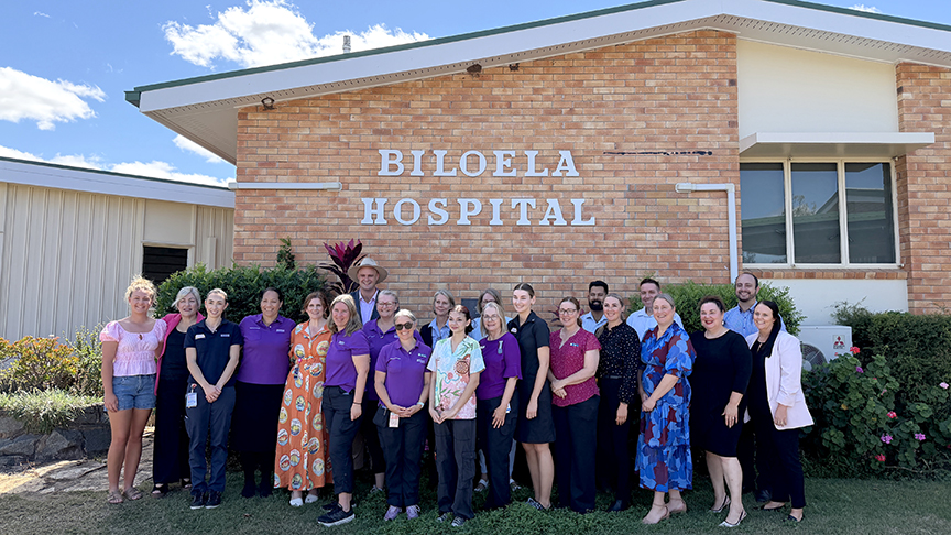 Staff and community standing in front of Biloela Hospital smiling at camera