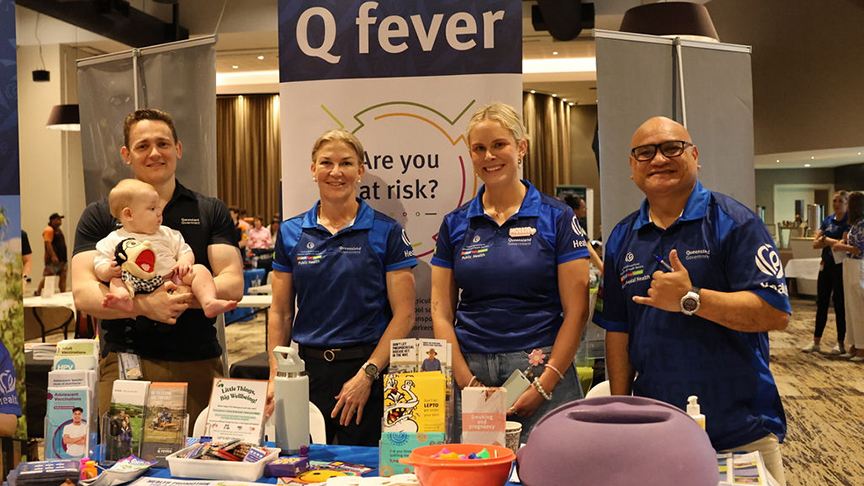 Four Central Queensland Health team members standing behind a health display table at the sport and health expo.