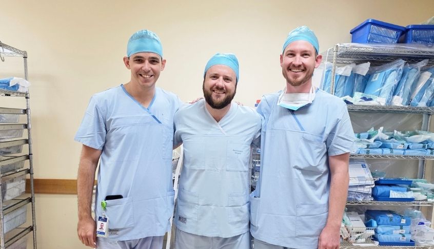Three rural generalist doctors smiling in their scrubs.